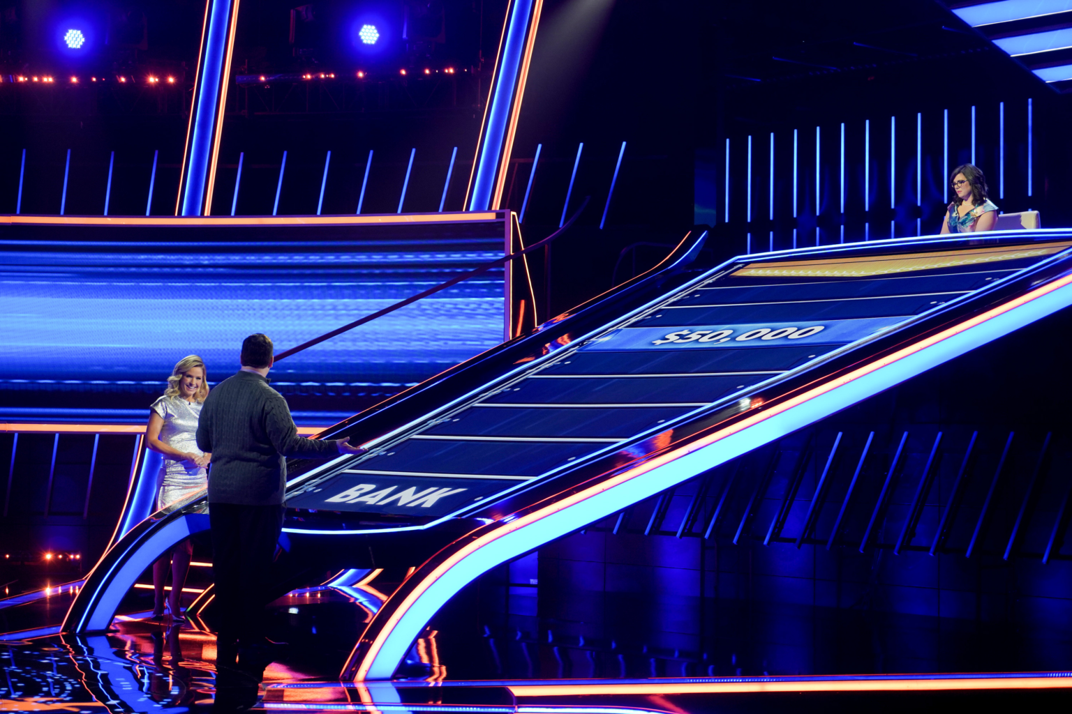 Scott Green on the set of The Chase with host Sara Haines, a chaser seated at the top of the board
