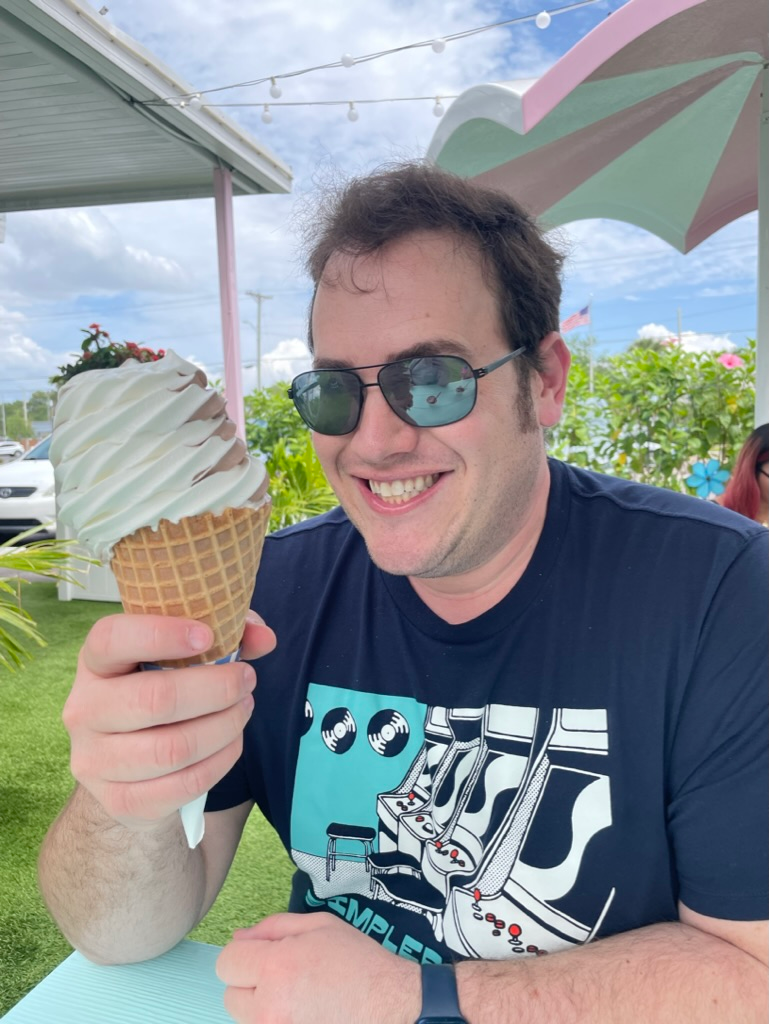 Scott Green in sunglasses, grinning at a giant soft-serve ice cream cone